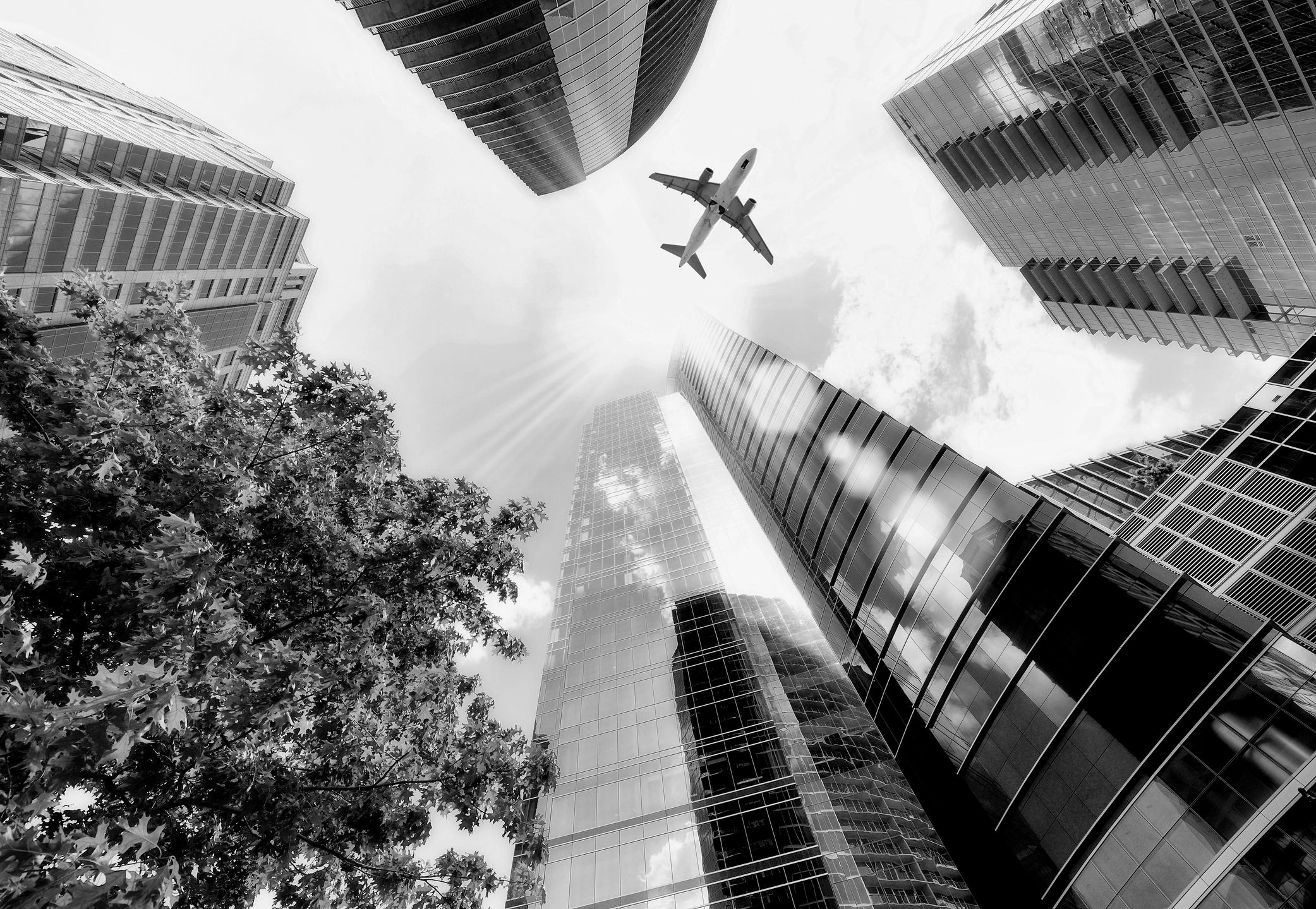 Aircraft flying over a dense modern skyline